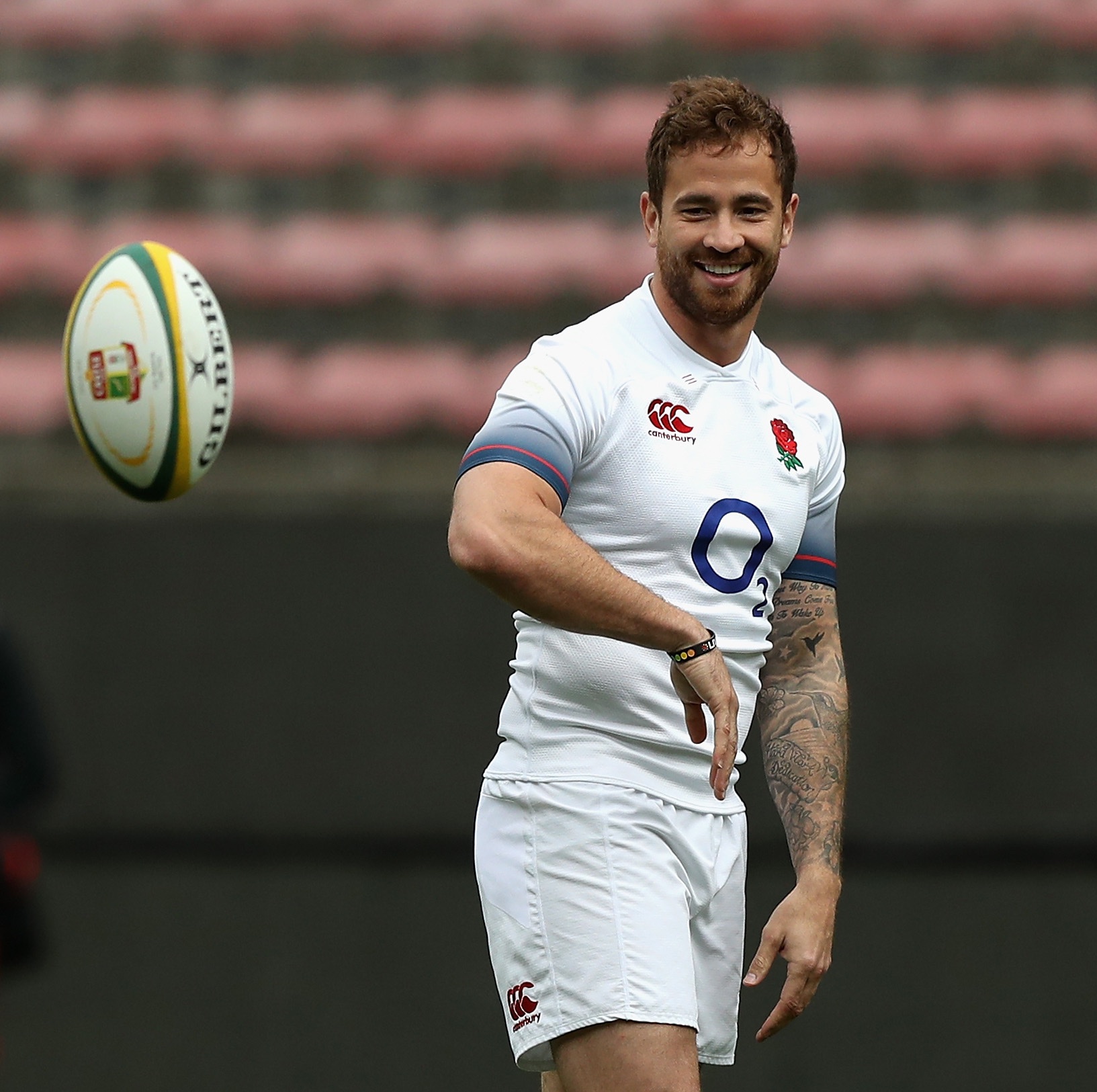 Danny Cipriani in an England rugby shirt watching a ball in flight