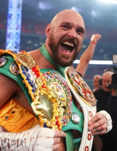 Tyson Fury celebrating with his championship belts at Wembley Stadium
